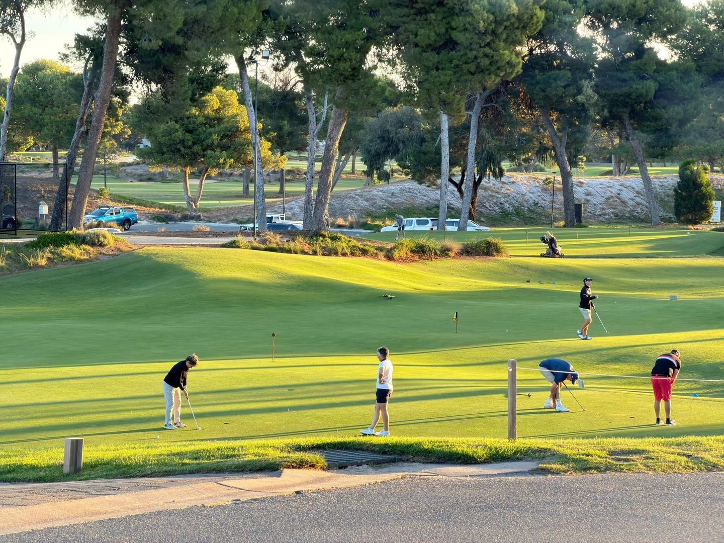 Golfeurs lisant et jouant leurs putts sur un green en pente