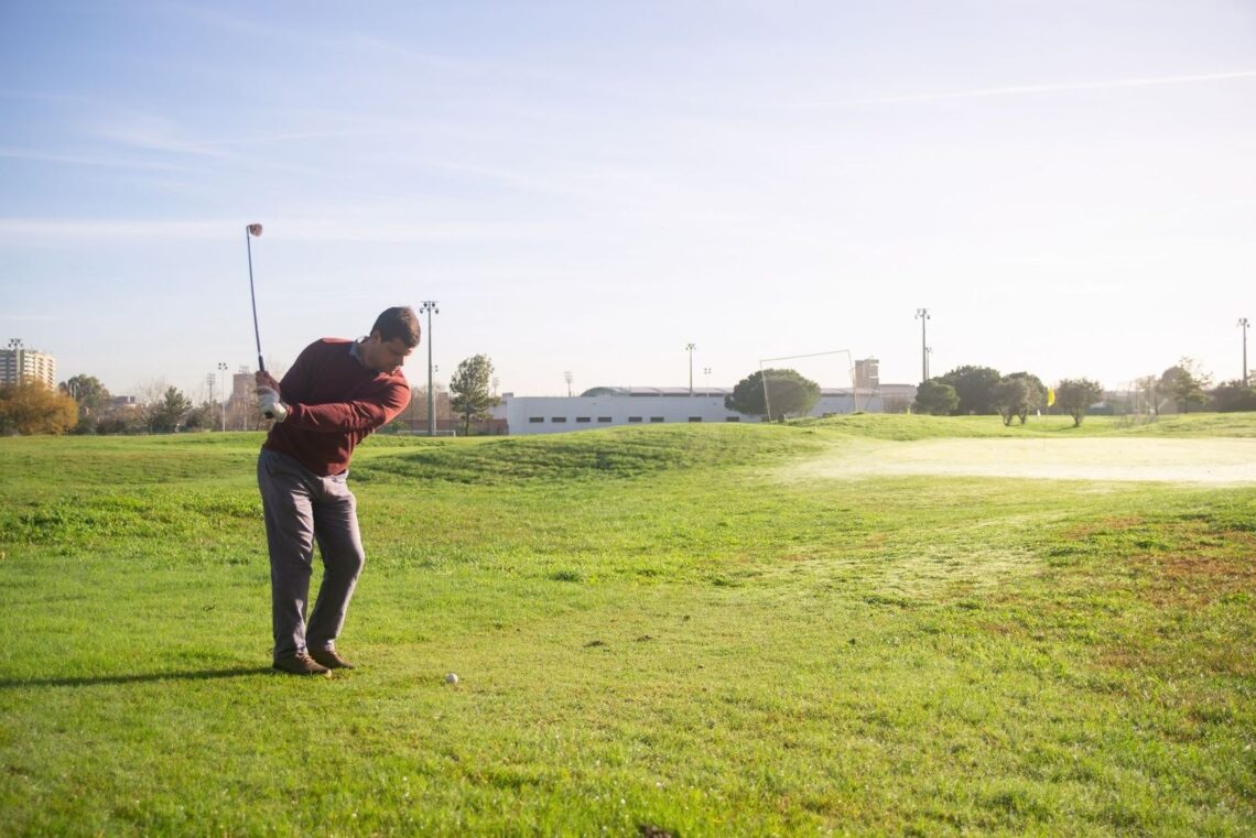 Golfeur en rotation avec son club sur un parcours en plein air