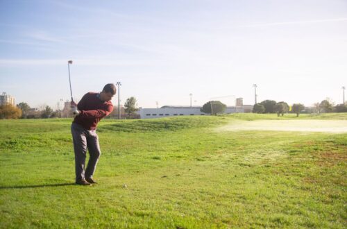 Golfeur en rotation avec son club sur un parcours en plein air