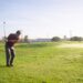 Golfeur en rotation avec son club sur un parcours en plein air