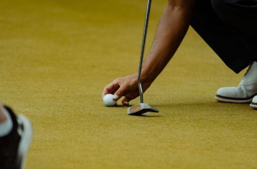 Golfeur alignant une balle sur le green avant un putt