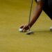Golfeur alignant une balle sur le green avant un putt