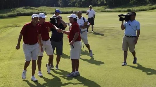 Des golfeurs se félicitent sur un parcours sous le regard des caméras